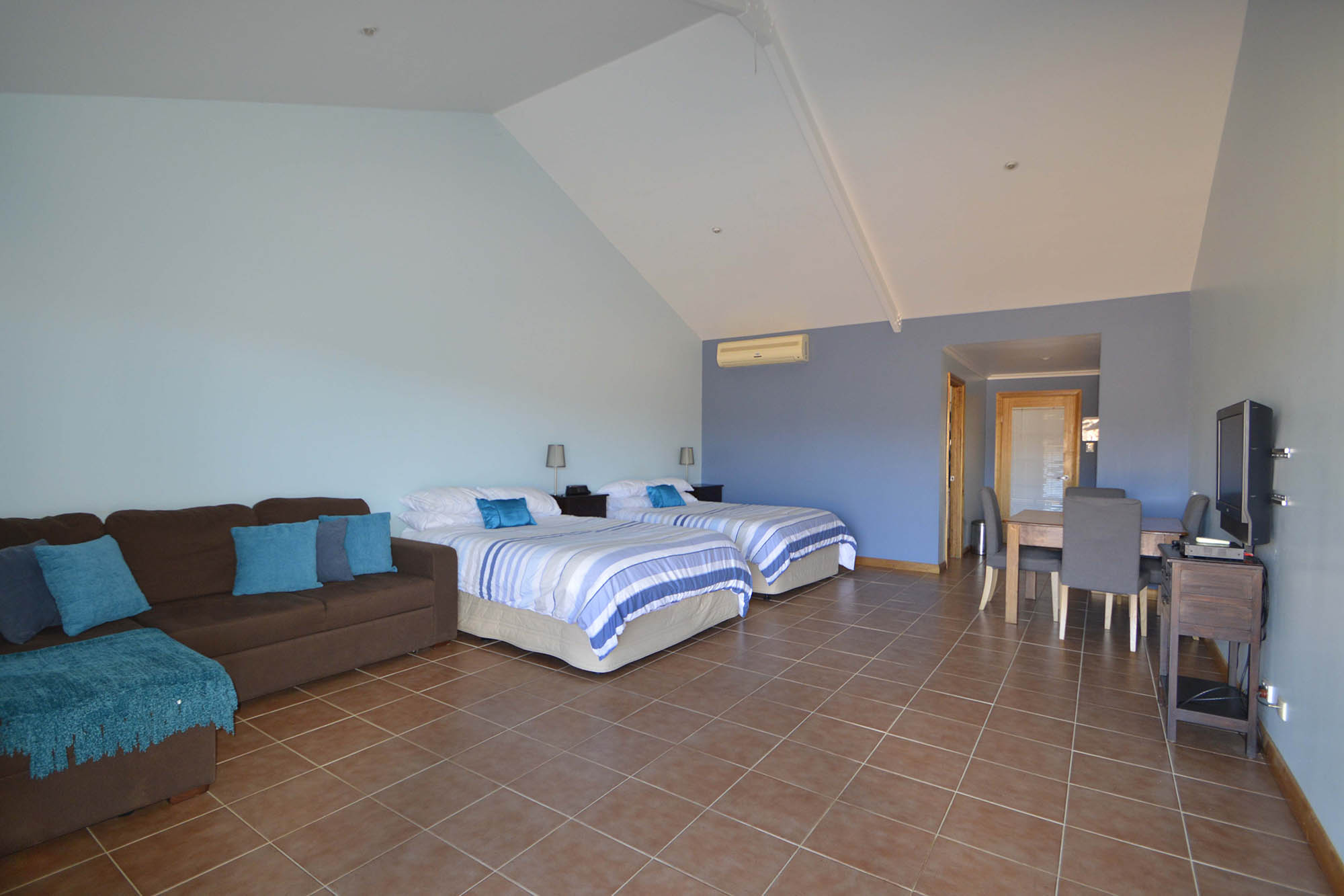 Mt Eltie room with a bed, sofa, dining area and kitchenette
