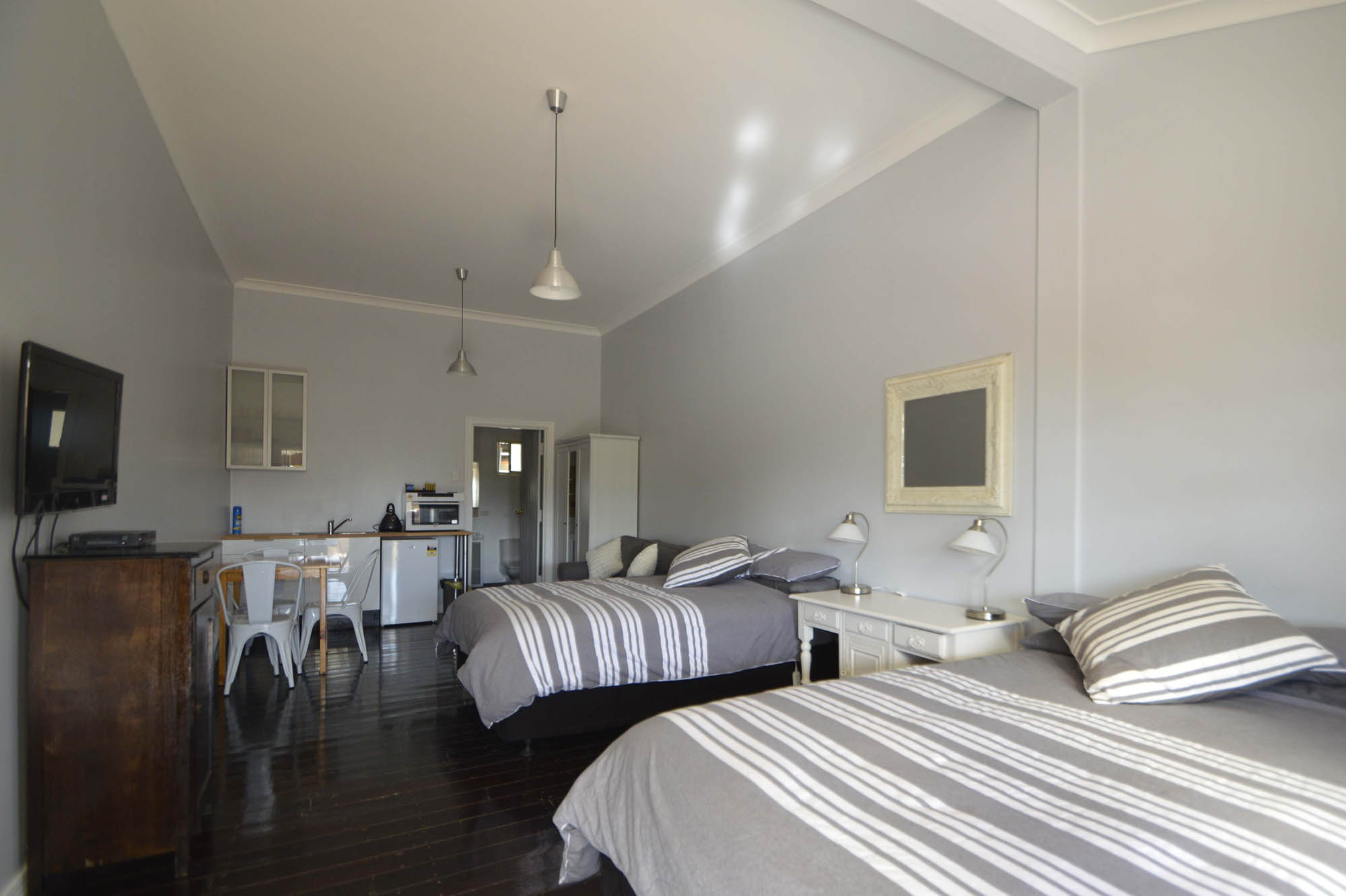Standard Room 1 with beds, dining table and kitchenette